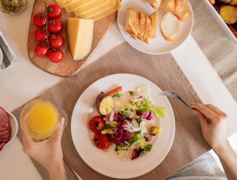 Top view of a delicious homemade meal with cheese, salad, and assorted ingredients.