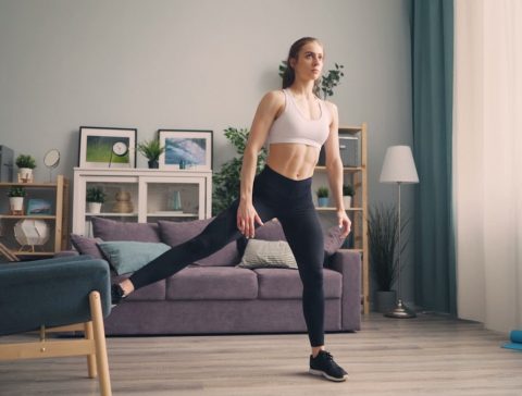 a woman in a sports bra top and leggings in a living room